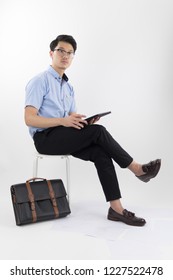 Clothes, Business, Luxury, Background, Fashion, Style Concept -   Young Asian Men Working With Tablet On White Chair With Blue Oxford Shirt Short Sleeve And Black Slack Pants On White Background