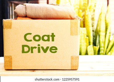 Clothes In Carton Box On Wood Table For Donation, Coat Drive Concept 