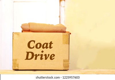 Clothes In Carton Box On Wood Table For Donation, Coat Drive Concept 