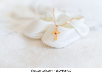 Clothes and a cross for the baby's christening. Selective focus. White.