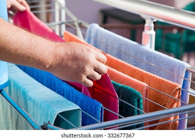 Clothes dryer with towels on balcony in sunlight