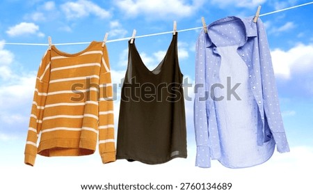 Clothes drying on laundry line against blue sky with clouds
