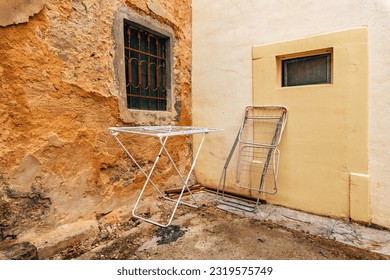 Clothes drying rack in back yard, next to the old house wall
