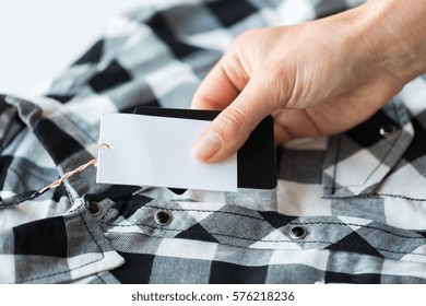 Clothes, Fashion, People And Shopping Concept - Close Up Of Hand Holding Checkered Shirt With Price Tag