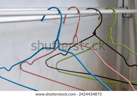 clothes hangers made of wire in various colors.