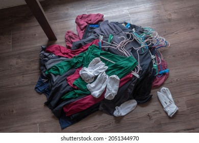 The Clothes In The Hangers Pile On The Floor Of The Room