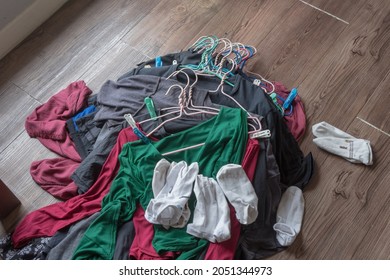 The Clothes In The Hangers Pile On The Floor Of The Room