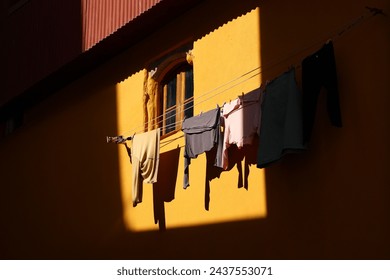 clothes hanging to dry on the window. photo with some clothes hanged out of the building to dry in plain sunlight. - Powered by Shutterstock