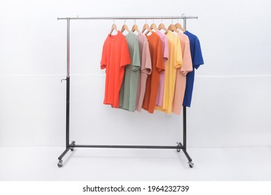 Clothes Hanging On Clothing Rack Wardrobe Fashion Apparel Selection Of Rainbow Color T-shirts On Closet Hanger

