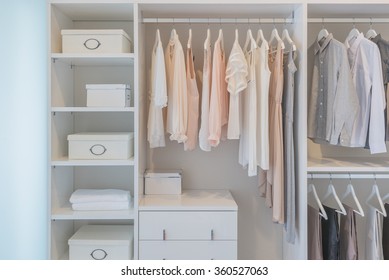 clothes hanging on rail in white wardrobe with boxes - Shutterstock ID 360527063