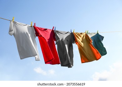 Clothes hanging on washing line against sky - Powered by Shutterstock