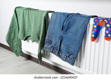 Clothes hanging on white radiator in room