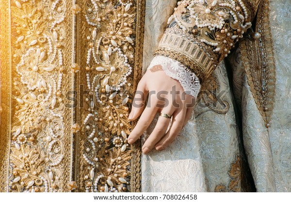 Clothes of a historical\
imperial woman with pastel tones, a hand with a ring with a\
precious stone