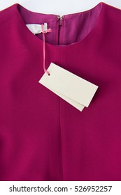 Clothes Label Tag On Raspberry Color Dress 