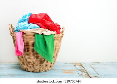 Clothes In A Laundry Wooden Basket On Wood Table