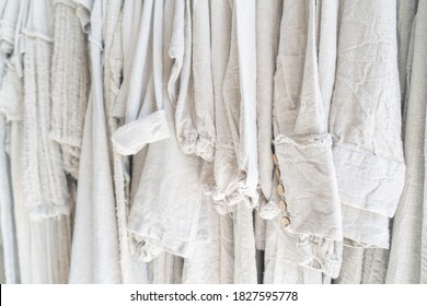 Clothes made from natural raw linen on hangers in a store close-up