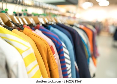 Clothes On Hangers - New Fashion Collection At Fashionable Clothes Store. Clothing Rental Or Secondhand Store Concept. Clothes Stall Against Blurred Store Background With Copy Space