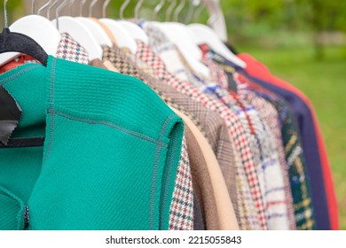 Clothes On Hangers - Second Hand Clothes Store Or Thrift Shopping Concept. Clothing Rental Service. Selective Focus. Car Boot Sale Outside