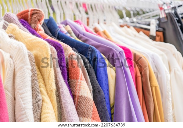 Clothes on hangers - second hand clothes\
store or thrift shopping concept. Clothing rental service. Clothes\
rail with copy space for text. Selective\
focus