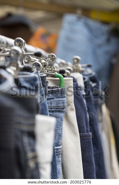 clothes on a rack on a flea\
market.