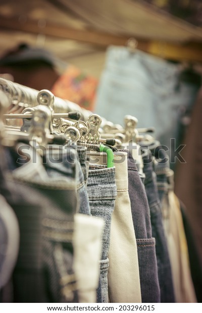 clothes on a rack on a flea\
market.