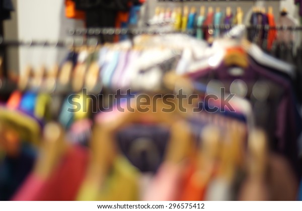 clothes on a rack on a flea market in bokeh.\
Defocus background