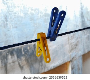 clothes pegs on hanging rope with wall background - Powered by Shutterstock