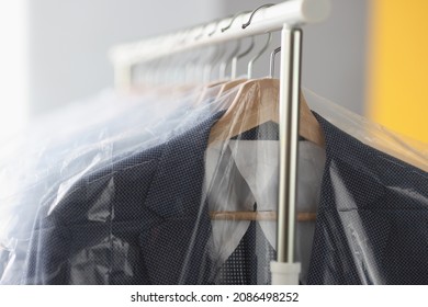 Clothes In Plastic Bags Hanging On Hanger In Laundry Closeup