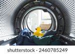 Clothes and rubber duck inside the washing machine, laundry and hygiene concept
