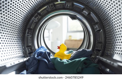 Clothes and rubber duck inside the washing machine, laundry and hygiene concept