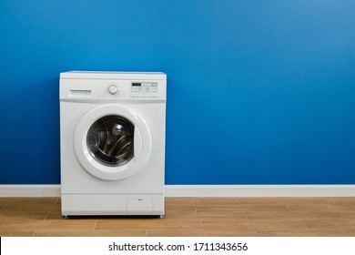 Clothes Washing Machine In Laundry Room Interior On Blue Wall, Copy Space