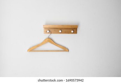Clothes wooden hanger on a white wall.