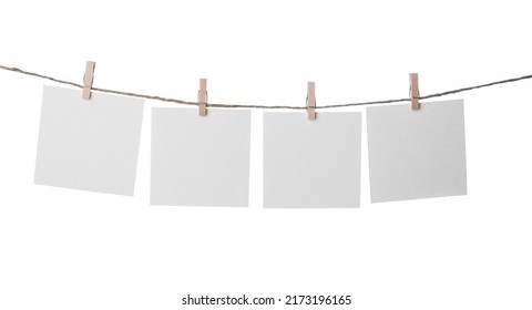 Clothespins with empty notepapers on string against white background. Space for text