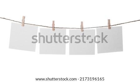 Clothespins with empty notepapers on string against white background. Space for text