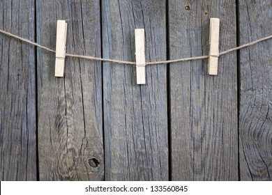 Clothespins on rope and empty vintage wooden planks background