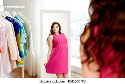 Clothing, Fashion And People Concept - Happy Plus Size Woman In Pink Dress Looking At Mirror At Home