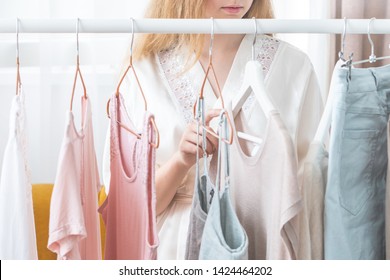 clothing, fashion, style and people concept - woman choosing clothes at home wardrobe  - Shutterstock ID 1424464202