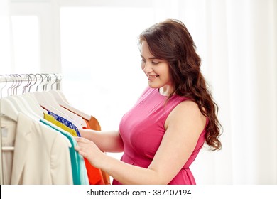 Clothing, Fashion, Style And People Concept - Happy Plus Size Woman Choosing Clothes At Home Wardrobe