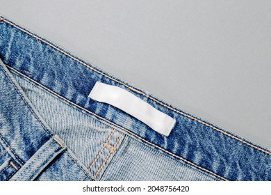 Clothing Label Inside Jeans On Grey Background. Mockup. Close Up