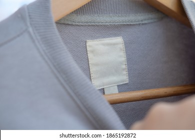 Clothing Label On Light Gray Fabric.  Fashion Brand Name Mock Up, Closeup, Top View