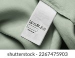 Clothing label on light green garment, top view