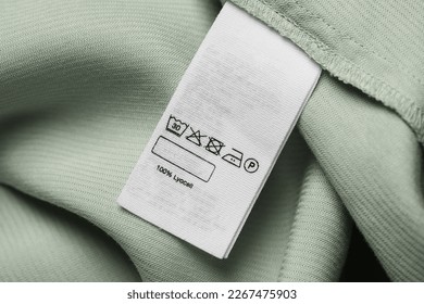 Clothing label on light green garment, top view