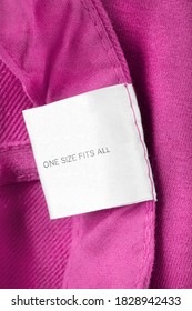 Clothing Label Says One Size Fits All On Pink Textile Background