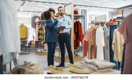 Clothing Store: Businesswoman Uses Tablet Computer, Talks to Visual Merchandising Specialist, Collaborate To Create Stylish Collection. Small Business Fashion Shop Sales Manager Talks to Designer. - Powered by Shutterstock