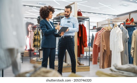 Clothing Store: Businesswoman Uses Tablet Computer, Talks to Visual Merchandising Specialist, Collaborate To Create Stylish Collection. Small Business Fashion Shop Sales Manager Talks to Designer. - Shutterstock ID 2053746320