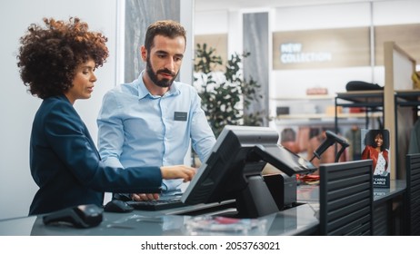Clothing Store Checkout Cashier Counter: Female Retail Sales Manager Explaining to New Male Assistant Employee Everything He Needs to Know About Working at Fashionable Shop with Stylish Brand Designs. - Shutterstock ID 2053763021
