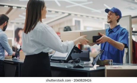 Clothing Store Checkout Cashier Counter: Retail Sales Managers Pack And Give Package Delivery Courier To Deliver Online Order. Fashion Shop Designer Brands Available For Online Shopping.