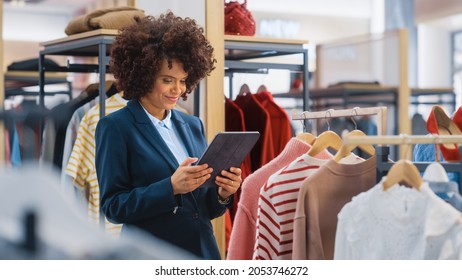 Clothing Store: Female Merchandising Manager Uses Tablet Computer To Create Stylish Fashion Collection. Professional Shop Sales Retail Assistant Checks Stock. Small Business Owner Orders Mall Items.