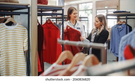 Clothing Store: Professional Sales Associate Talks With Beautiful Female Customer, Shopping Stylish Clothes, Choosing Trendy, Sustainable Brands. Small Business Owner And Designer Talking To Client