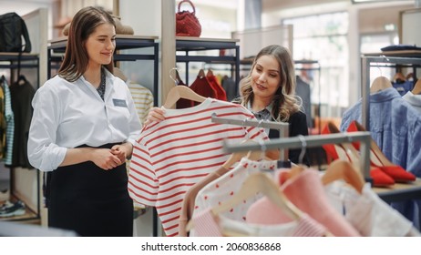 Clothing Store: Professional Sales Associate Talks With Beautiful Female Customer, Shopping Stylish Clothes, Choosing Trendy, Sustainable Brands. Small Business Owner And Designer Talking To Client